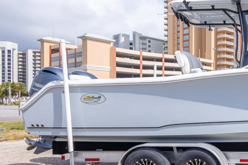 Slide: The Image of 2022 Sea Hunt Gamefish 27 boat on trailer, urban background with buildings. - 44