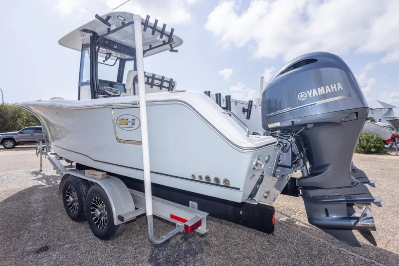 Slide: The Image of 2022 Sea Hunt Gamefish 27 boat with Yamaha engine on trailer, parked outdoors. - 55