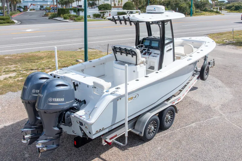 Slide: The Image of 2022 Sea Hunt Gamefish 27 boat with dual Yamaha engines on a trailer. - 4