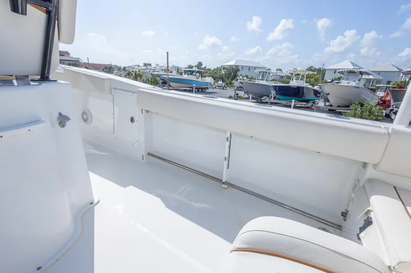 Slide: The Image of 2022 Sea Hunt Gamefish 27 boat interior with white seating and clear sky background. - 43
