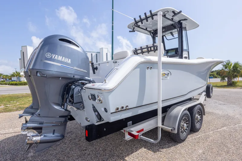 Slide: The Image of 2022 Sea Hunt Gamefish 27 boat with Yamaha engine on a trailer, parked outdoors. - 52