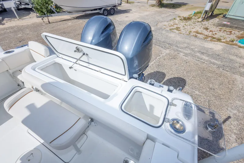 Slide: The Image of 2022 Sea Hunt Gamefish 27 boat with open storage compartments and dual outboard motors. - 39