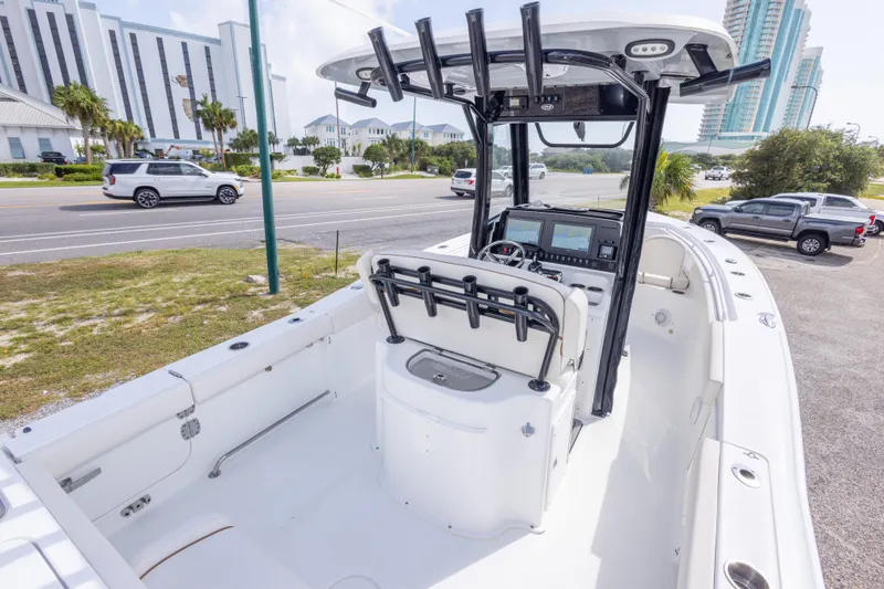 Slide: The Image of 2022 Sea Hunt Gamefish 27 boat with modern console and seating, parked near a road. - 15