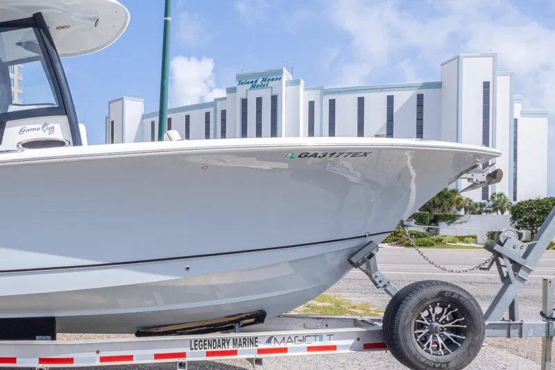 Slide: The Image of 2022 Sea Hunt Gamefish 27 boat on trailer, hotel in background. - 45