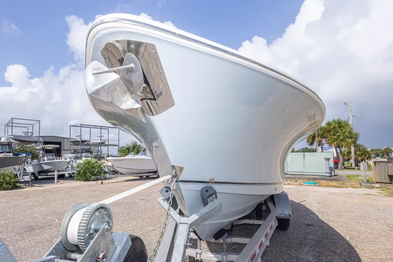 Slide: The Image of 2022 Sea Hunt Gamefish 27 boat on trailer, parked outdoors under cloudy sky. - 58