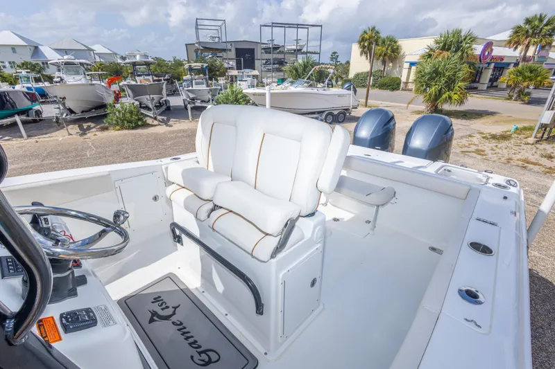Slide: The Image of 2022 Sea Hunt Gamefish 27 boat interior with dual engines and white seating. - 33
