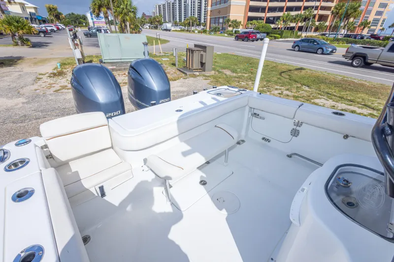 Slide: The Image of 2022 Sea Hunt Gamefish 27 boat interior with dual Yamaha engines, parked near a road. - 36
