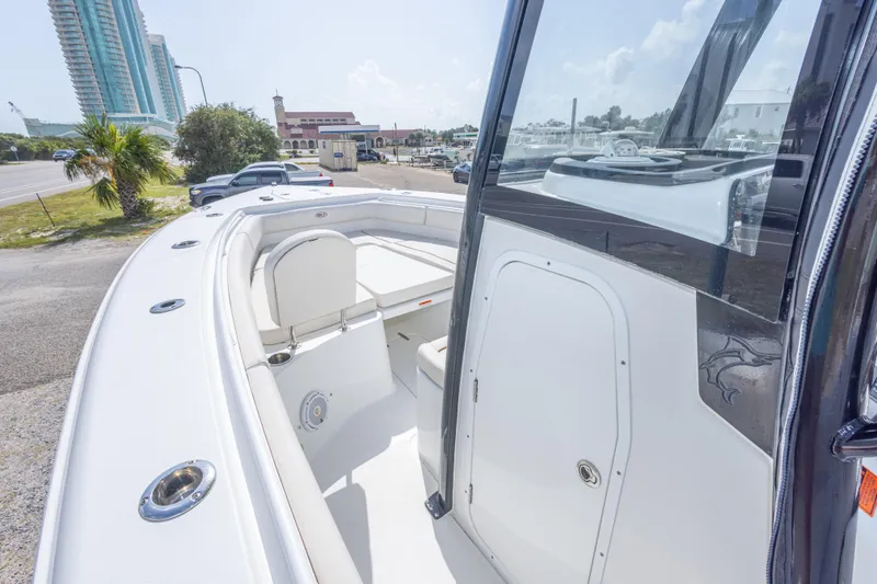 Slide: The Image of 2022 Sea Hunt Gamefish 27 boat interior with seating and storage, parked near buildings. - 23