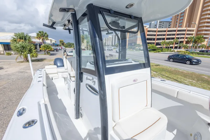 Slide: The Image of 2022 Sea Hunt Gamefish 27 boat docked near a coastal road with palm trees. - 31
