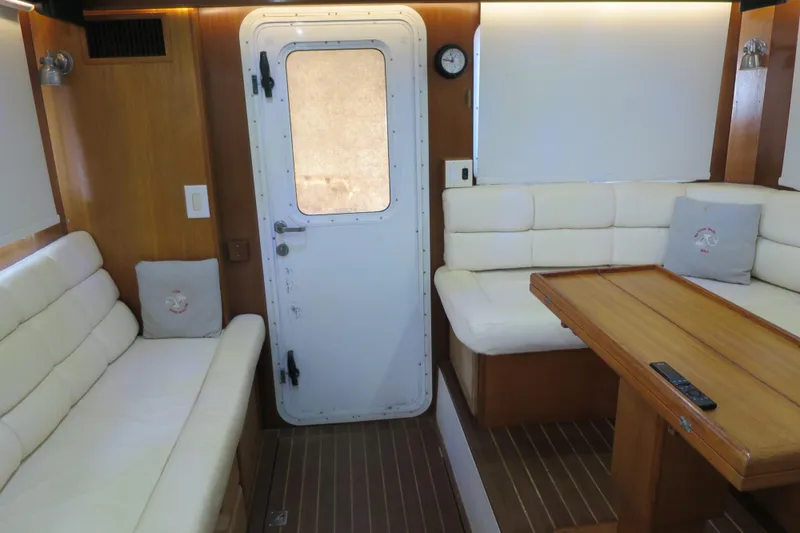 Slide: The Image of Interior of 2007 Grand Harbour N47 yacht with white seating and wooden table. - 38