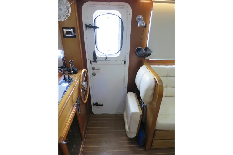 Slide: The Image of Interior of 2007 Grand Harbour N47 yacht with wooden helm and white seating. - 36
