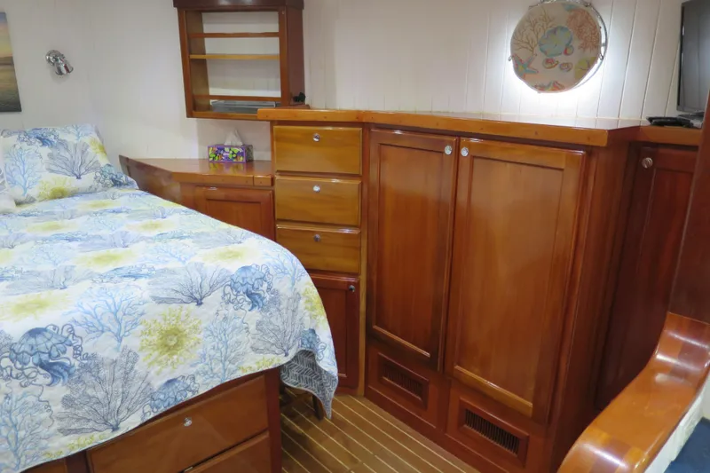 Slide: The Image of Luxurious 2007 Grand Harbour N47 yacht cabin with wooden cabinetry and floral bedding. - 18