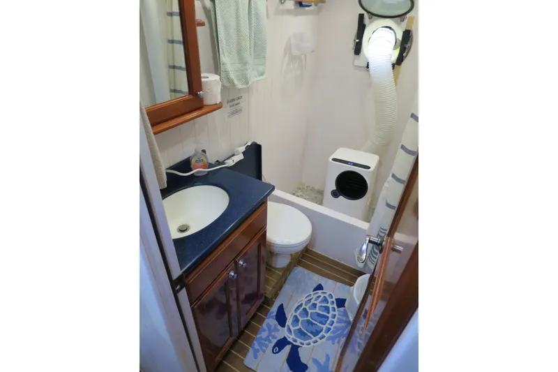 Slide: The Image of Compact bathroom in 2007 Grand Harbour N47 yacht with sink, toilet, and nautical decor. - 23