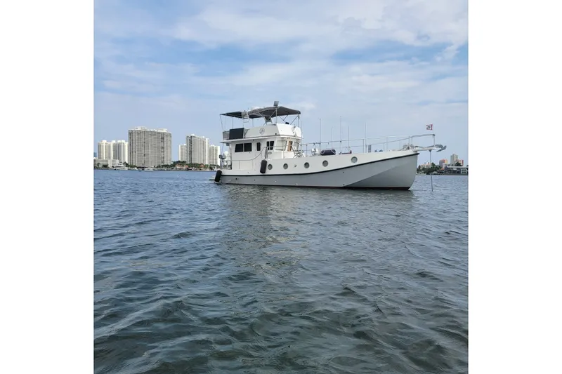 Slide: The Image of 2007 Grand Harbour N47 yacht on water with city skyline in background. - 1