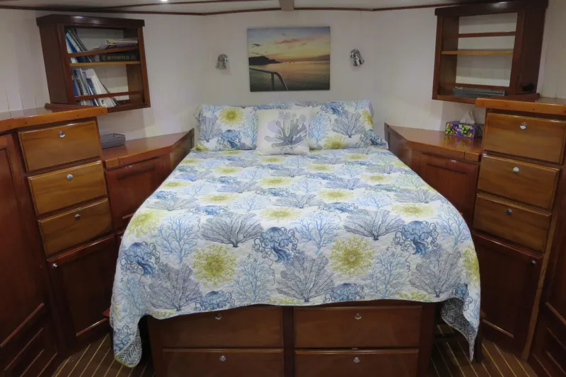 Slide: The Image of Luxurious 2007 Grand Harbour N47 yacht bedroom with floral bedding and wooden cabinetry. - 17