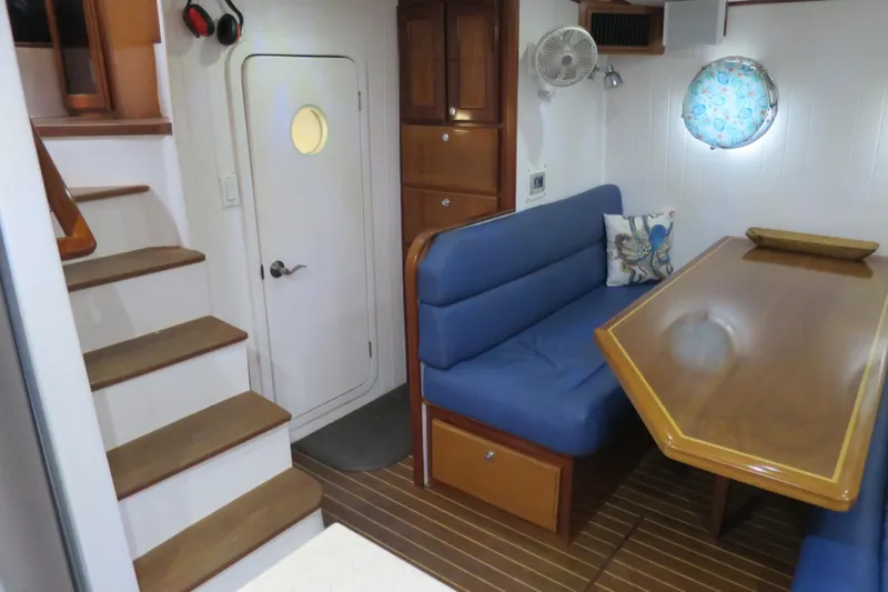 Slide: The Image of Interior of 2007 Grand Harbour N47 yacht with blue seating and wooden table. - 31