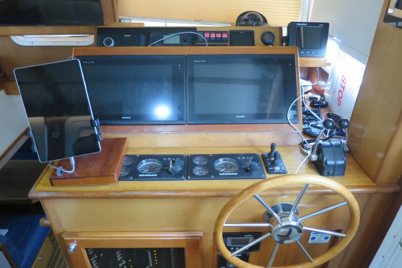 Slide: The Image of Pilothouse of 2007 Grand Harbour N47 yacht with navigation screens and wooden steering wheel. - 16