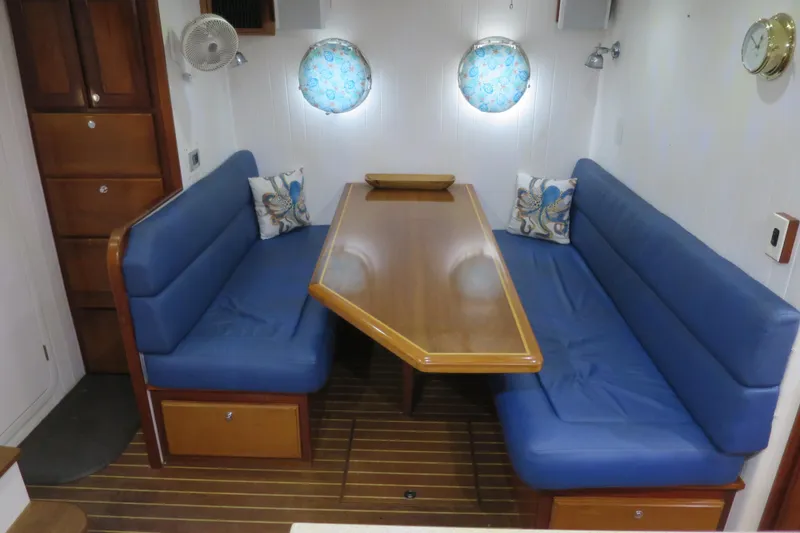 Slide: The Image of Interior of 2007 Grand Harbour N47 yacht with blue seating and wooden table. - 30