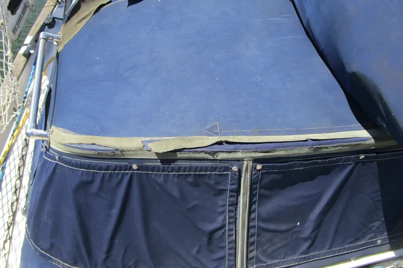 Slide: The Image of A blue boat cover with zippers and stitching, attached to a railing. - 9