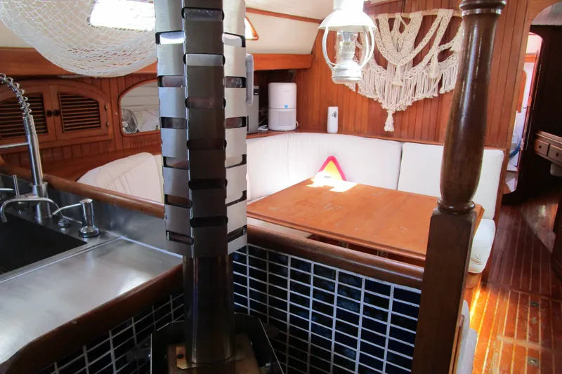Slide: The Image of Cozy interior of a 1980 Passport 40 sailboat with wood accents and seating area. - 35