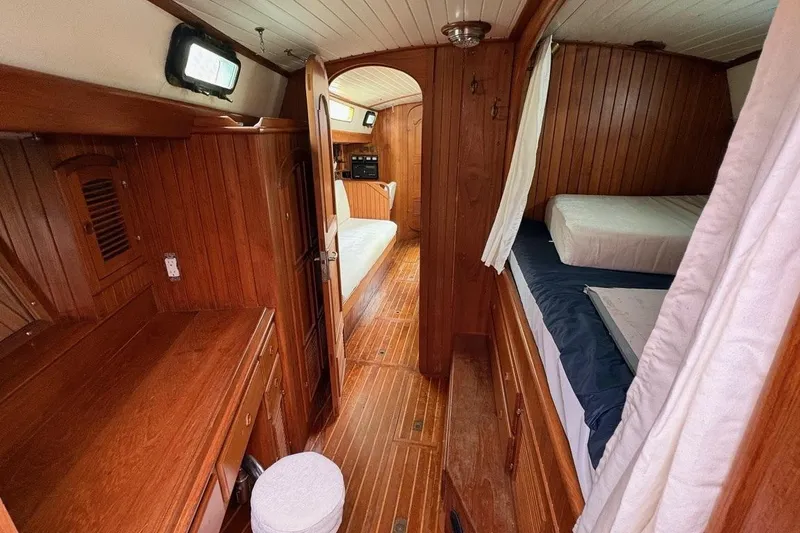 Slide: The Image of Interior of a 1980 Passport 40 sailboat with wooden paneling and cozy sleeping quarters. - 4
