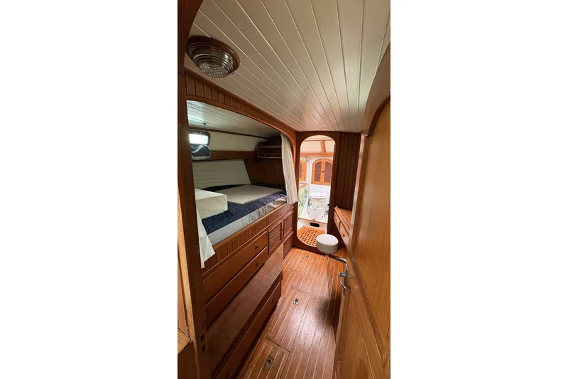 Slide: The Image of Interior of a 1980 Passport 40 sailboat cabin with wooden furnishings and cozy bedding. - 23