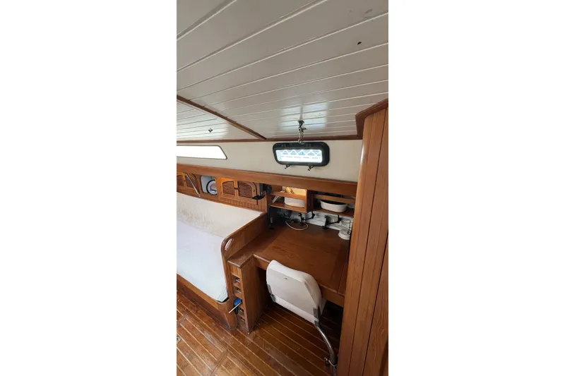 Slide: The Image of Interior of 1980 Passport 40 sailboat with wooden desk and storage shelves. - 27