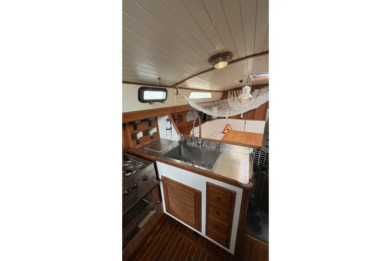 Slide: The Image of Interior of 1980 Passport 40 sailboat galley with wooden cabinetry and stainless steel sink. - 31