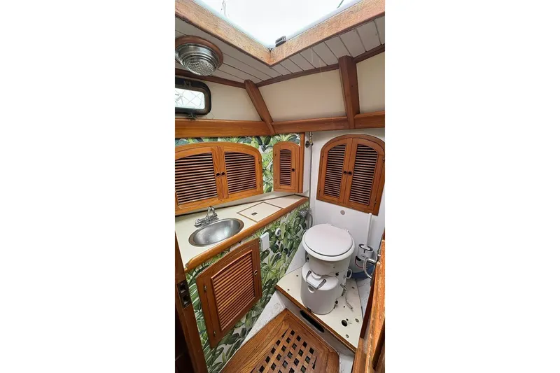 Slide: The Image of Vintage 1980 Passport 40 yacht bathroom with wooden accents and compact design. - 6
