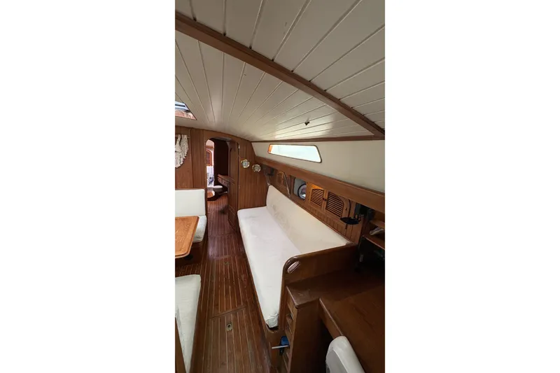 Slide: The Image of Interior of 1980 Passport 40 sailboat with wooden paneling and cozy seating area. - 26