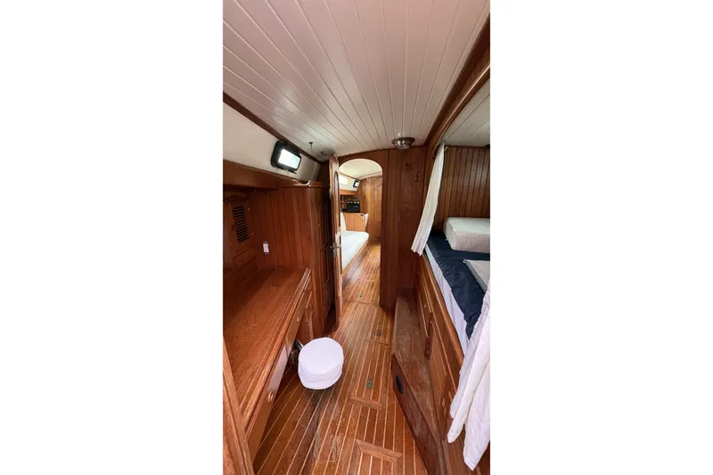 Slide: The Image of Interior of 1980 Passport 40 sailboat with wooden paneling and cozy sleeping area. - 24