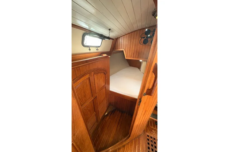 Slide: The Image of Cozy wooden cabin interior of 1980 Passport 40 sailboat with bed and porthole. - 22