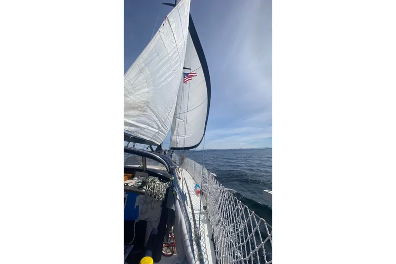 Slide: The Image of Sailing on a 1980 Passport 40 yacht with sails unfurled on open sea. - 2