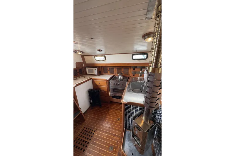 Slide: The Image of Interior of 1980 Passport 40 sailboat galley with wood finish and stove. - 28