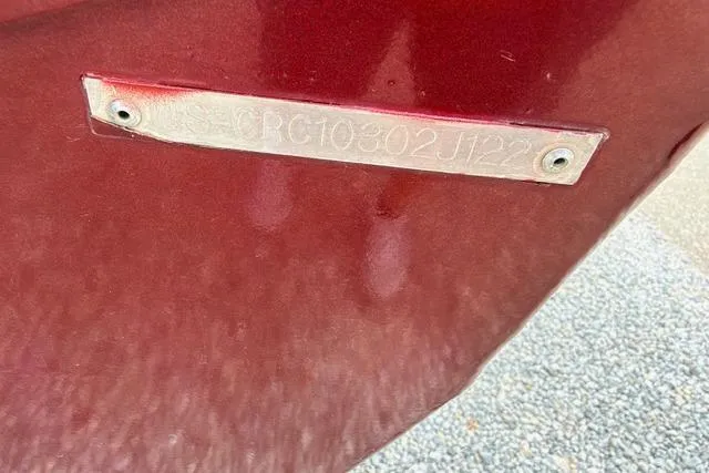 Slide: The Image of 2022 Crestliner MX 21 boat hull identification number plate on red surface. - 3