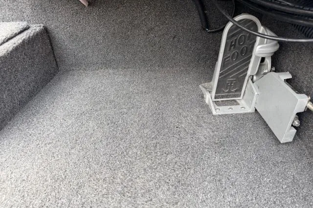Slide: The Image of Carpeted interior of a 2022 Crestliner MX 21 boat with foot pedal. - 6