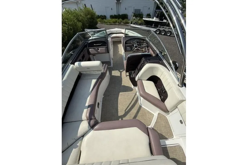 Slide: The Image of 2012 Cobalt 276 boat interior with beige and brown seating, steering wheel, and dashboard. - 26