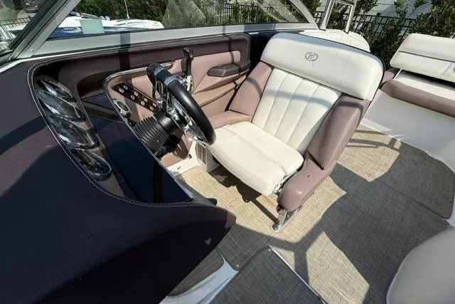 Slide: The Image of Interior of a 2012 Cobalt 276 boat, featuring a sleek steering wheel and comfortable seating. - 19