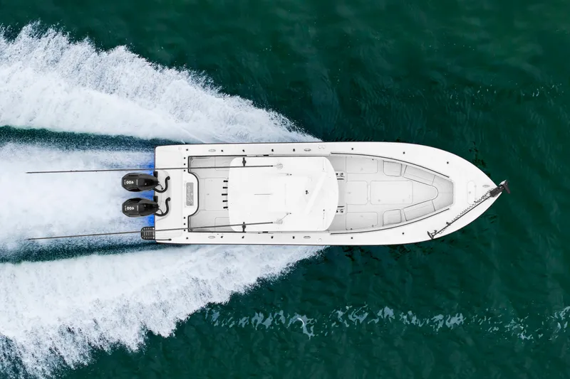 Slide: The Image of Aerial view of a white boat speeding across the water, featuring two outboard engines. - 1