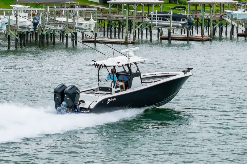 Slide: The Image of A black boat speeding on the water, featuring two outboard engines and a covered helm station. - 45