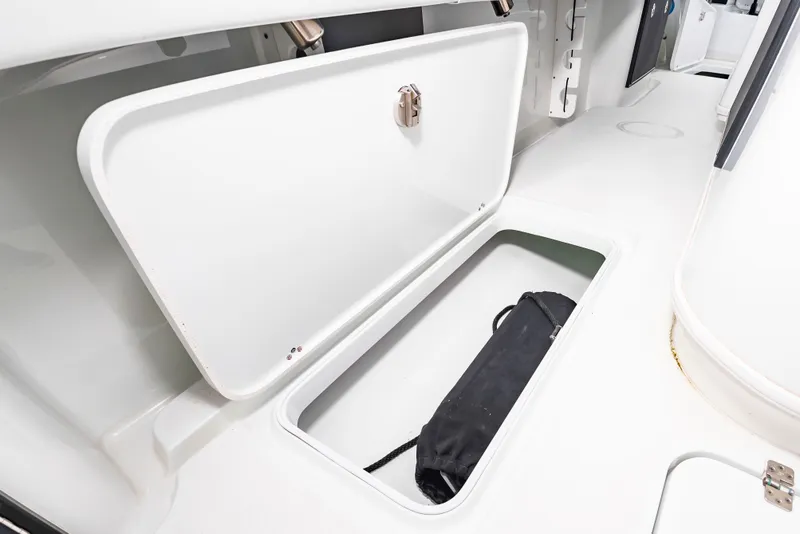 Slide: The Image of An open storage compartment on a boat with a black bag inside. - 22