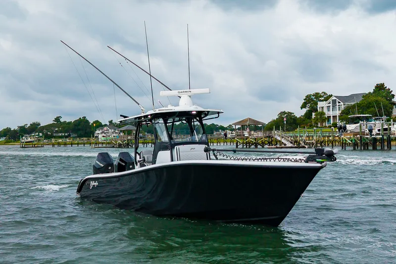 Slide: The Image of A black boat cruising on the water, featuring fishing rods and a radar on the roof. - 38