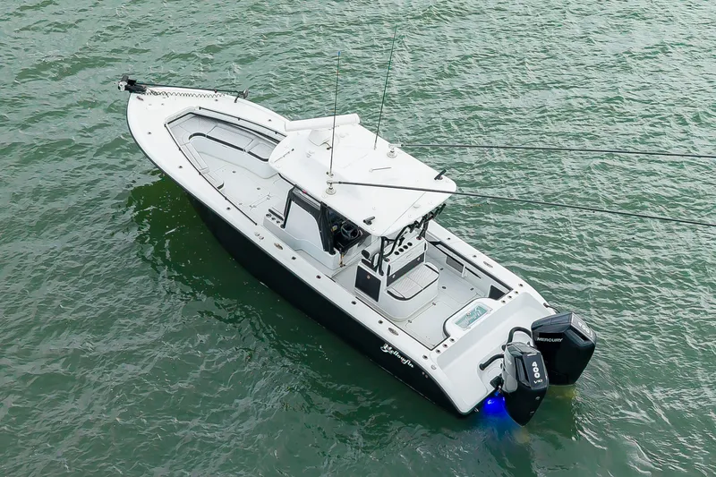 Slide: The Image of A 2025 Yellowfin 32 Offshore boat on the water with dual outboard engines and a spacious deck. - 42