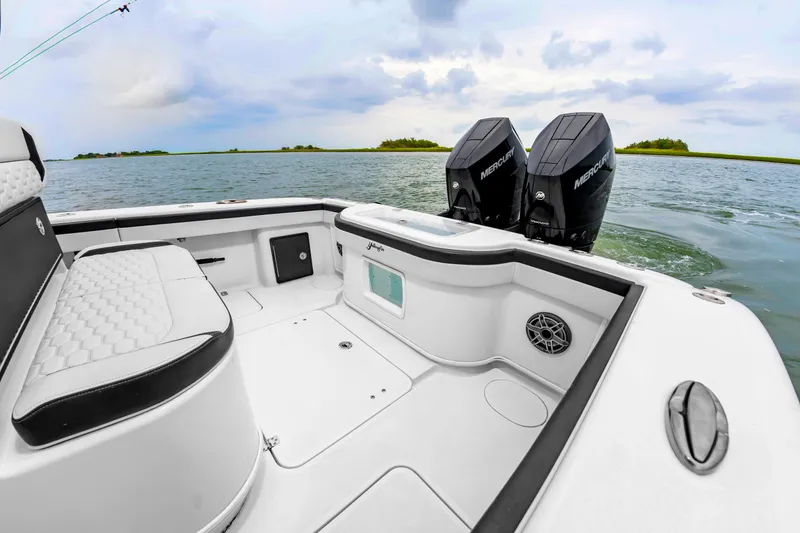 Slide: The Image of The image shows the stern of a Yellowfin 32 Offshore boat with twin outboard motors on calm water. - 16