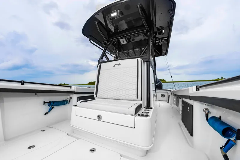 Slide: The Image of The image shows the cockpit of a 2025 Yellowfin 32 Offshore boat with white upholstery. - 32