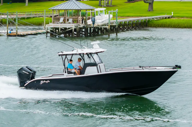 Slide: The Image of A black motorboat speeds along a river. Two people are seated in the cockpit. - 44