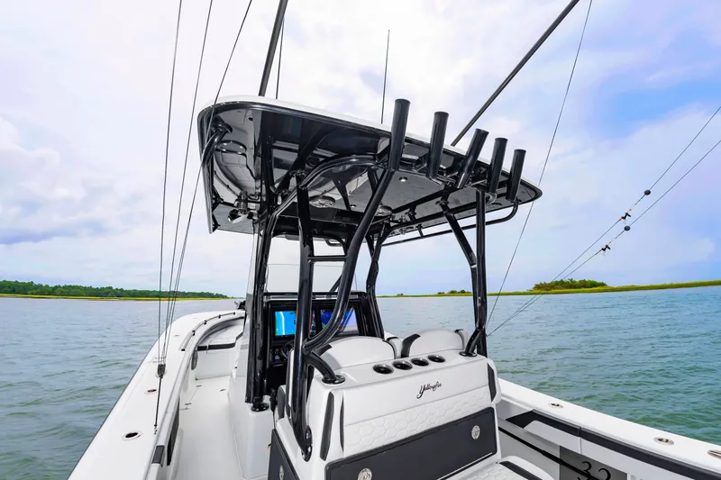 Slide: The Image of The image shows a modern boat with a black T-top and multiple fishing rod holders. - 27