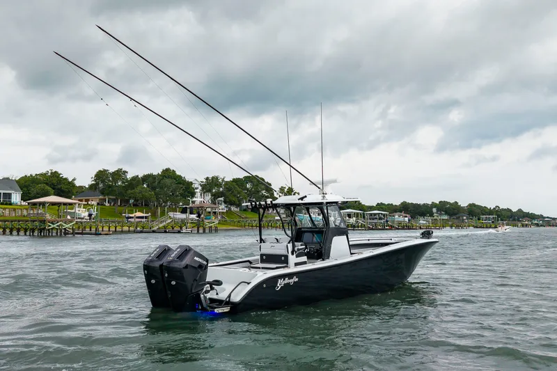 Slide: The Image of A 2025 Yellowfin 32 Offshore boat on the water with dual outboard engines and fishing rods. - 40