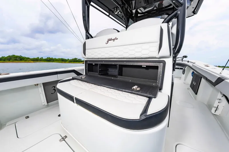 Slide: The Image of The image shows the cockpit of a 2025 Yellowfin 32 Offshore with white upholstery and storage space. - 24