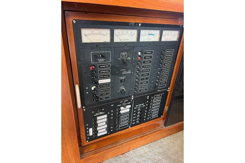 Slide: The Image of Electrical control panel on a 1994 Mikelson 64 yacht, featuring gauges and switches. - 42